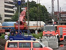 Durch Kran wiederaufgerichteter Kesselwagon, sowie im Vordergund Fahrzeuge der Feuerweh Düsseldorf und eines THW-Lichtmastes